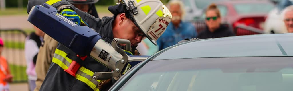 A Summerside firefighter using hydraulic rescue tools on a vehicle